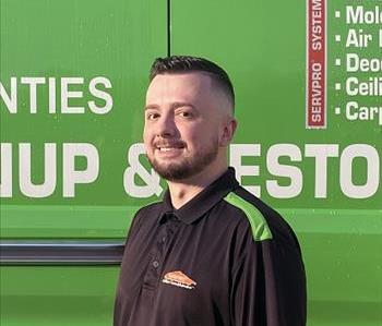 Rob a man standing in front of a green servpro van as the backdrop